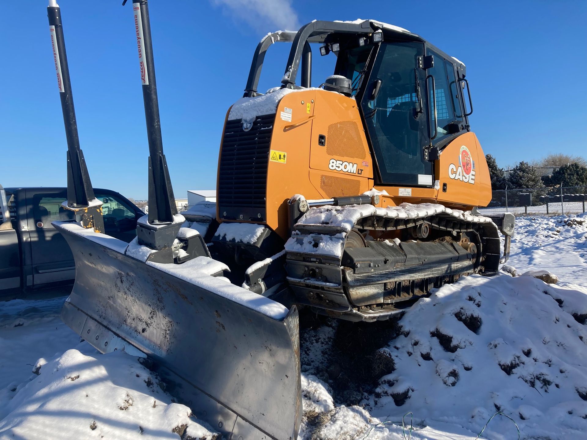 A bulldozer is parked in a snowy field.