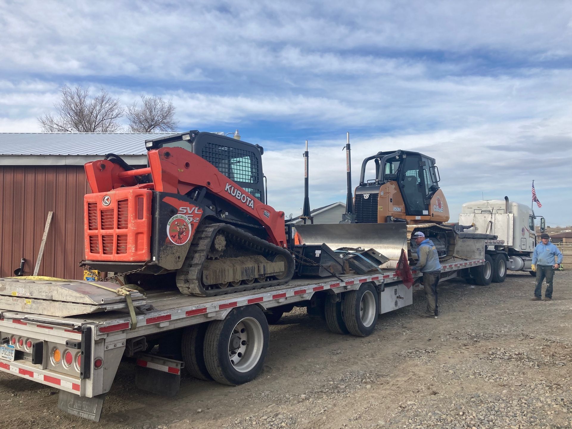 A bulldozer is being transported on a flatbed truck.
