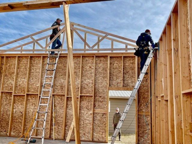 Two men are working on the roof of a house