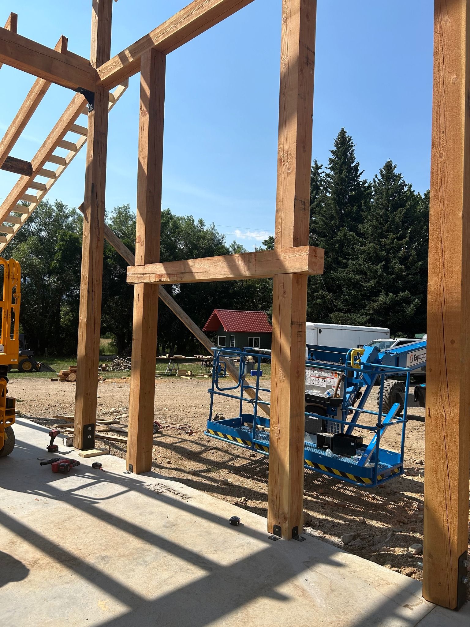 A large wooden structure is being built on a construction site.
