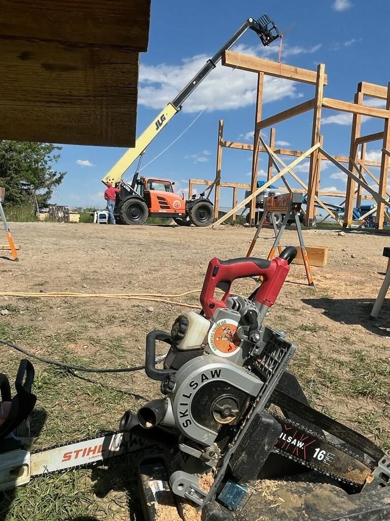 A chainsaw is sitting next to a circular saw on a construction site.