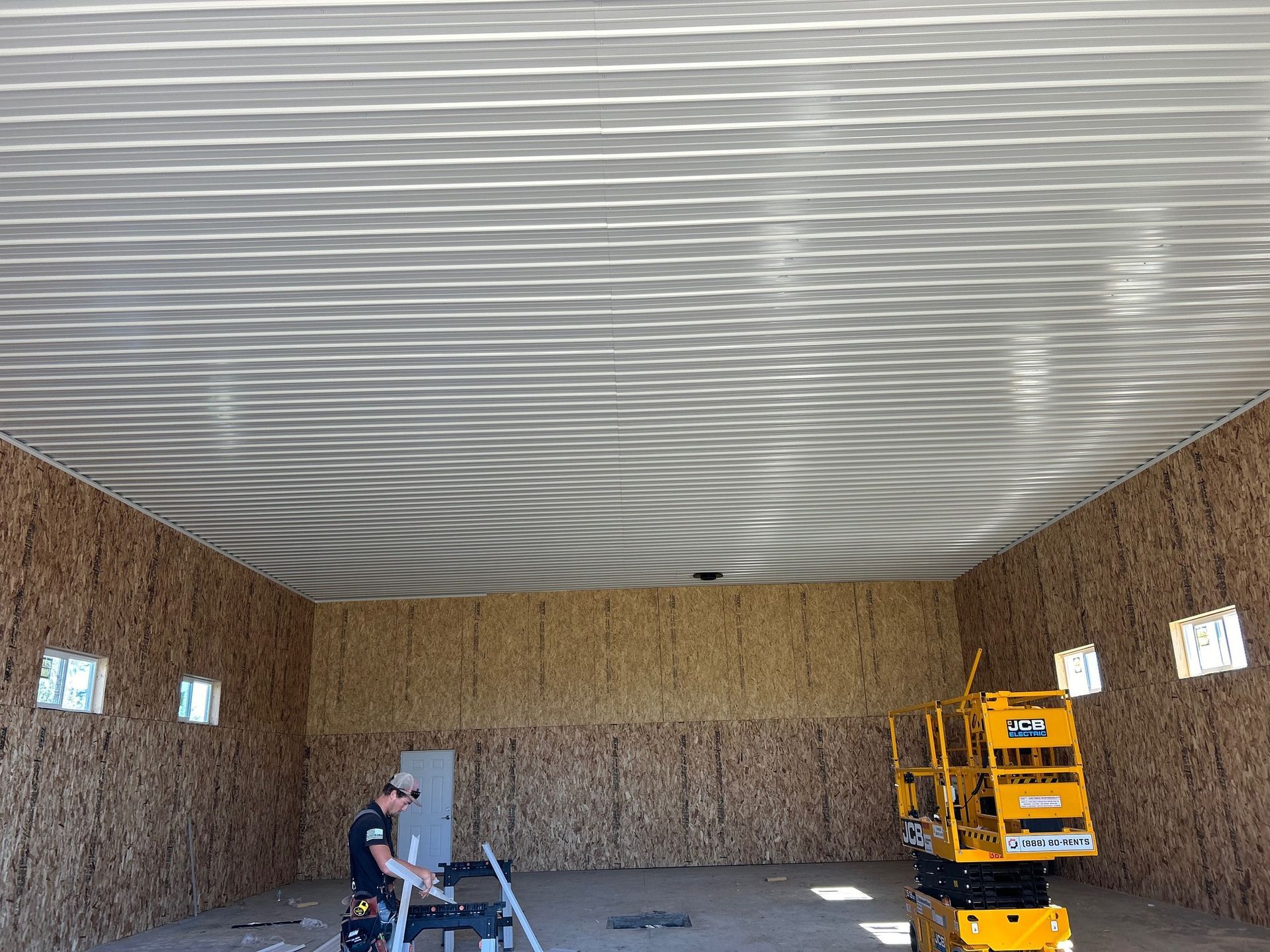 A man is standing on a ladder in a large room.