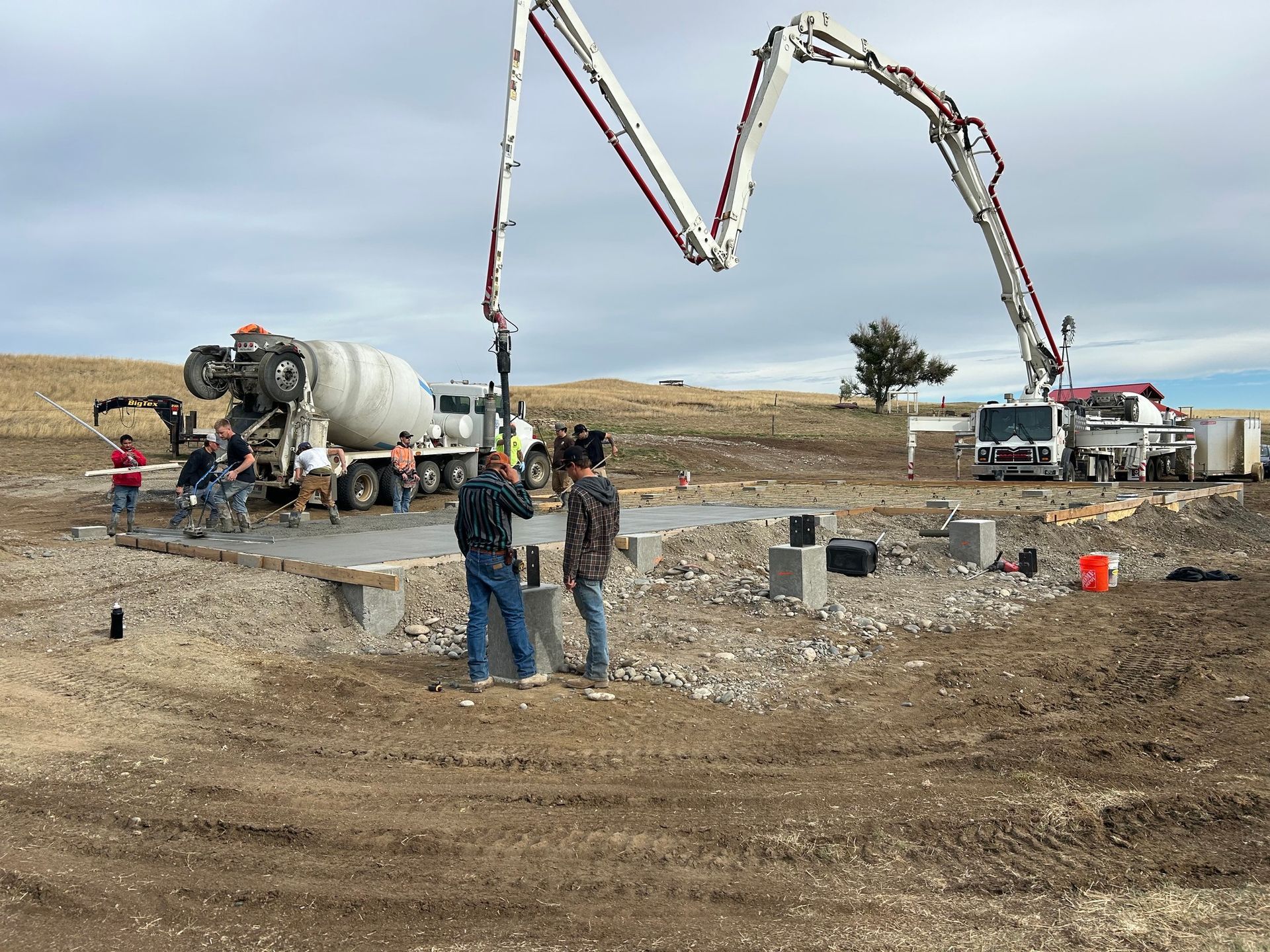 A concrete pump is being used to pour concrete on a construction site.