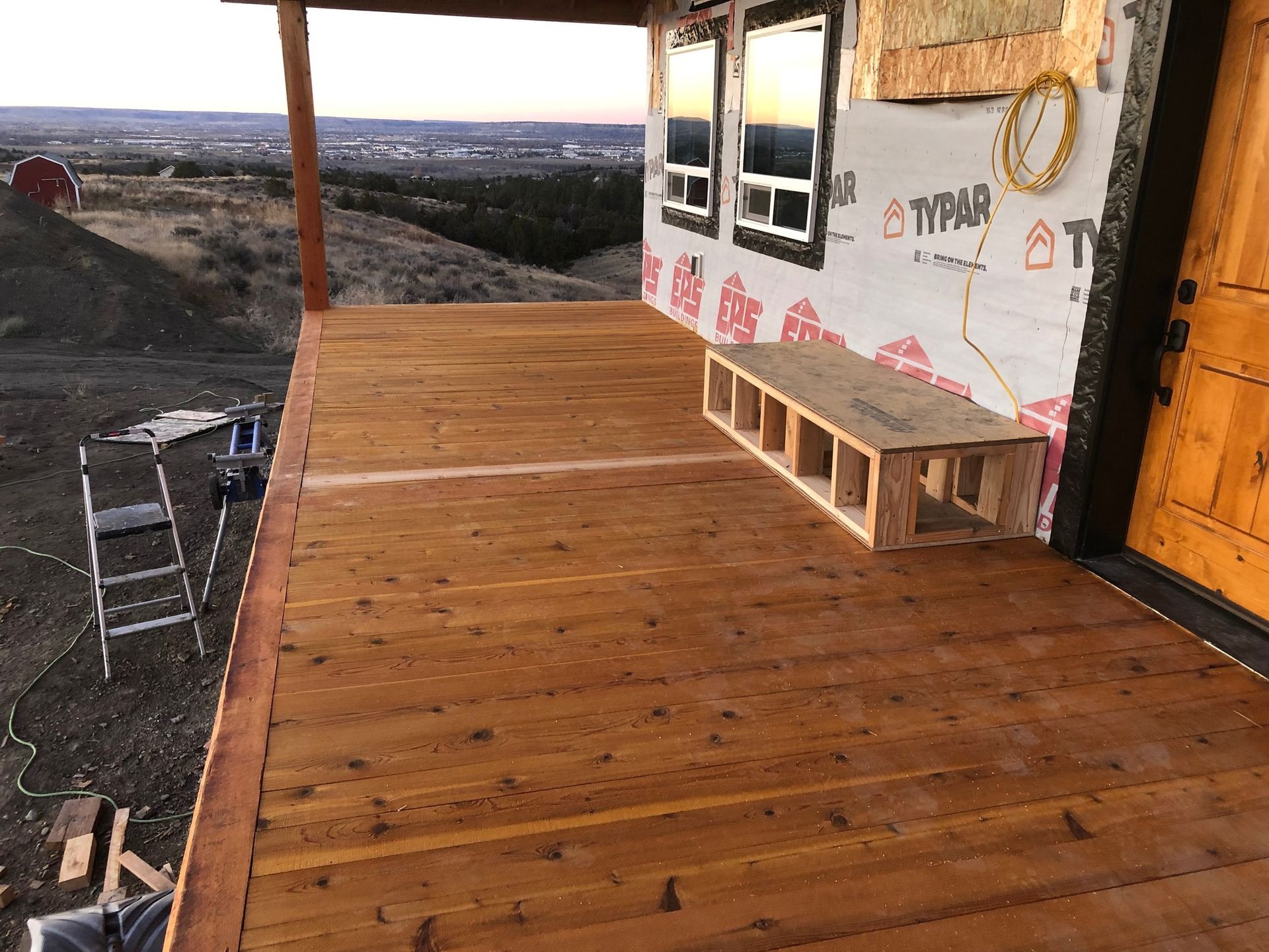 A wooden deck is being built on the side of a house.