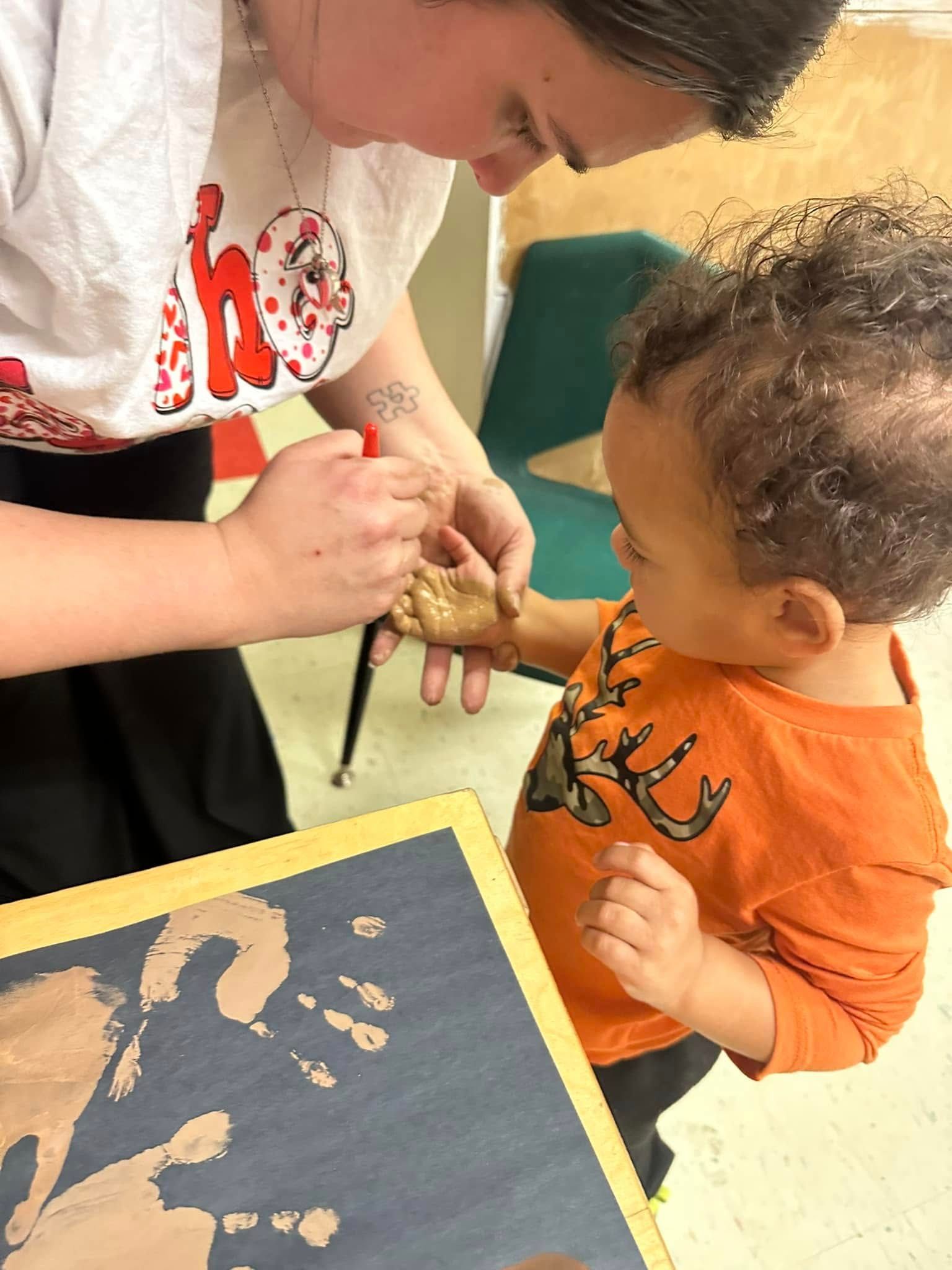 A woman and a child are playing with clay.