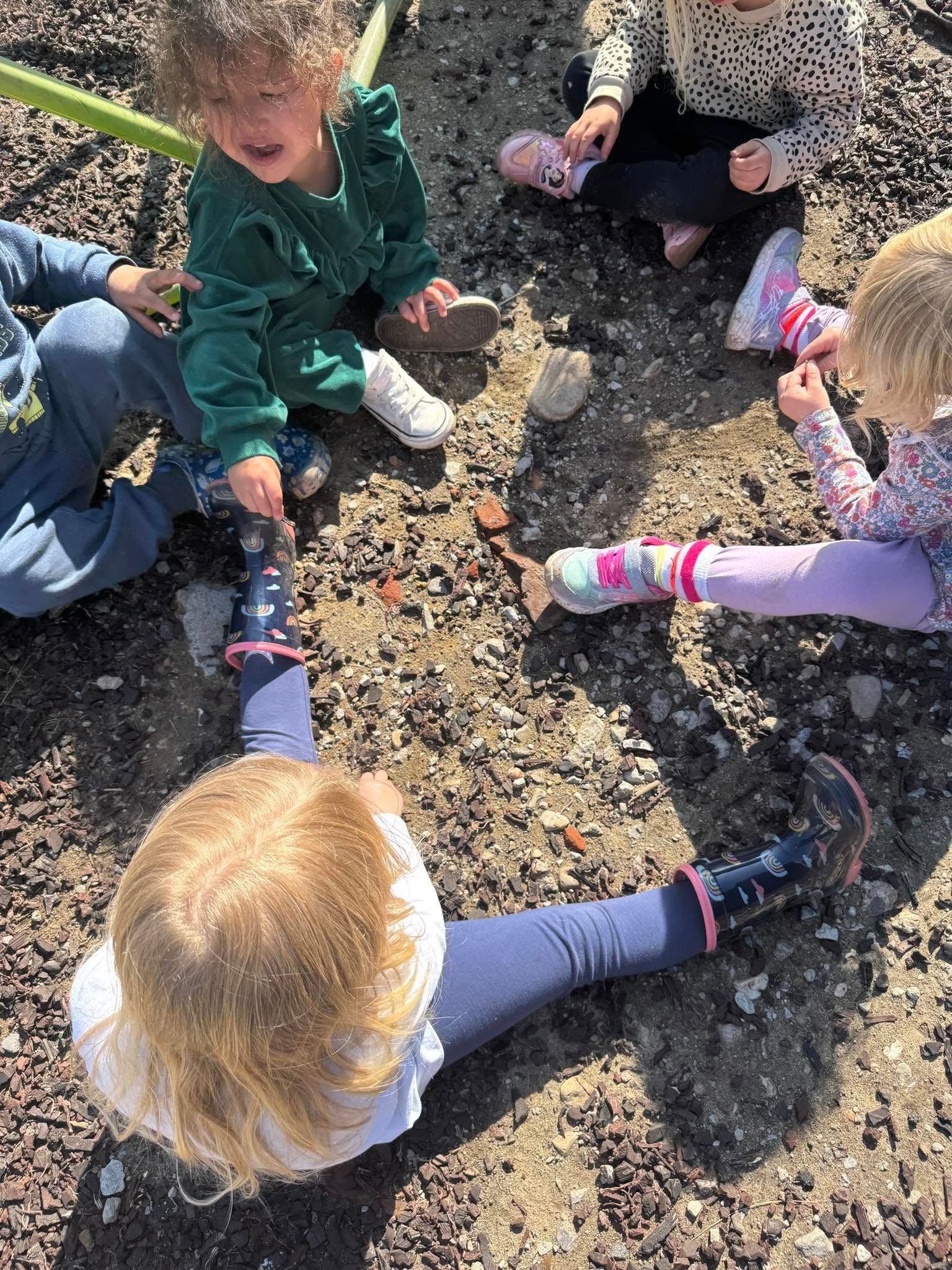 A group of children are sitting in a circle on the ground.