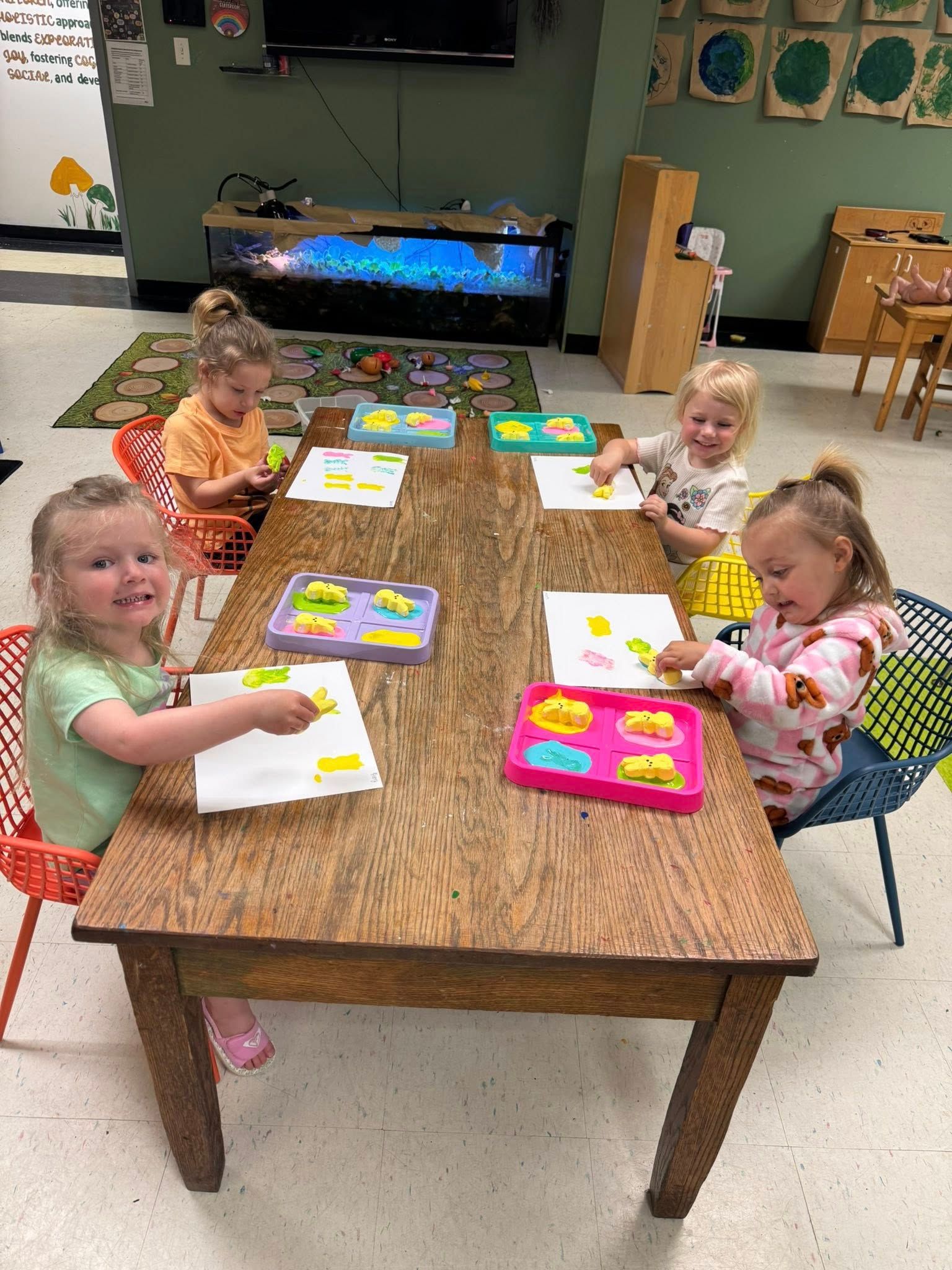 A group of young girls are sitting at a table in a classroom.