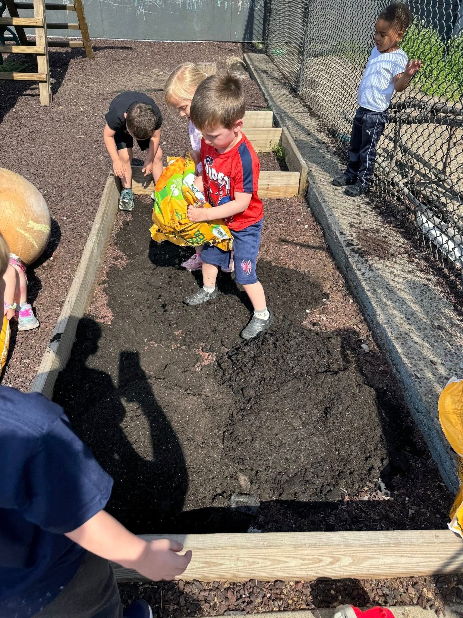 A group of young children are playing in a garden.