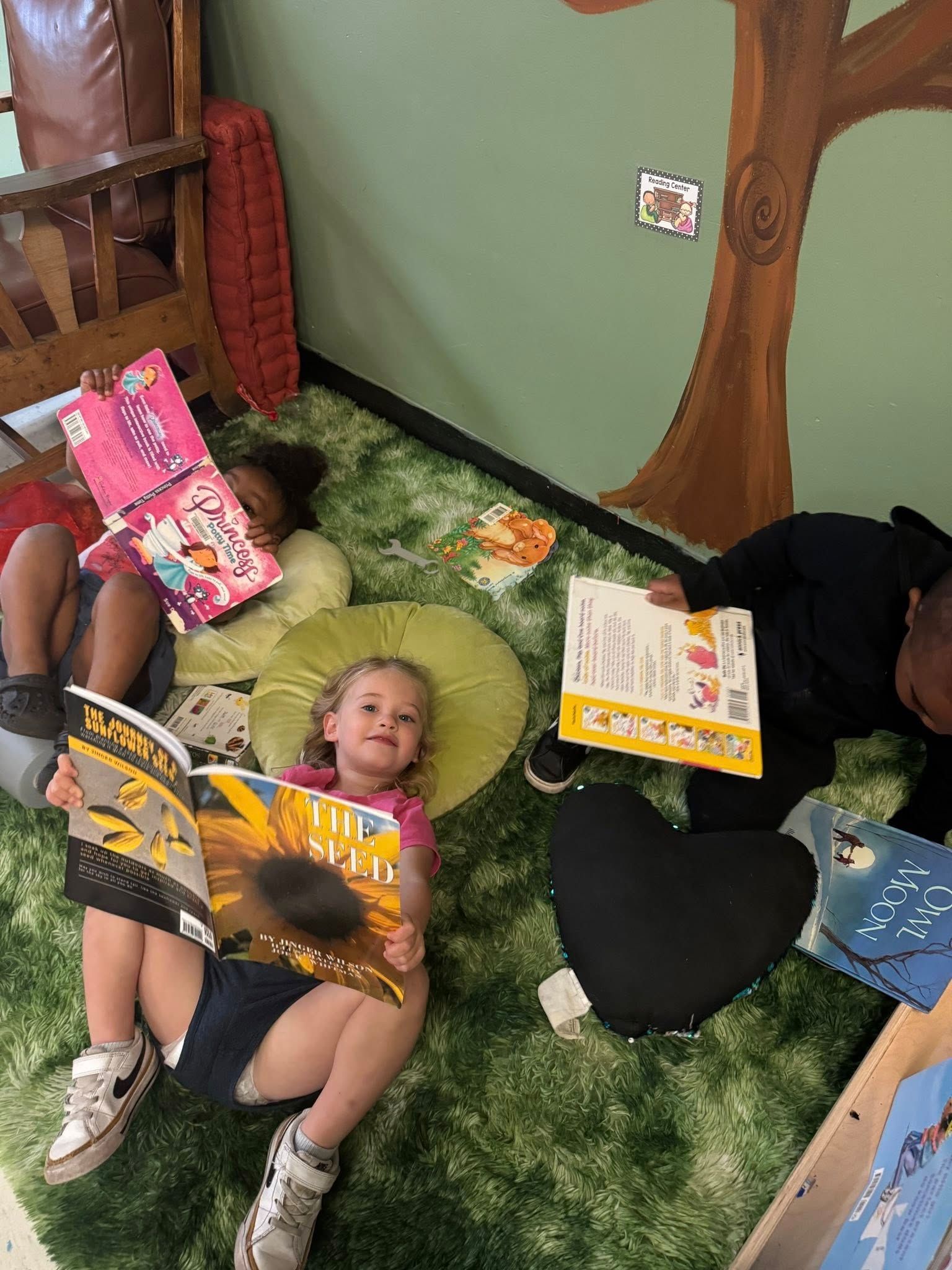 A group of children reading on a green carpet