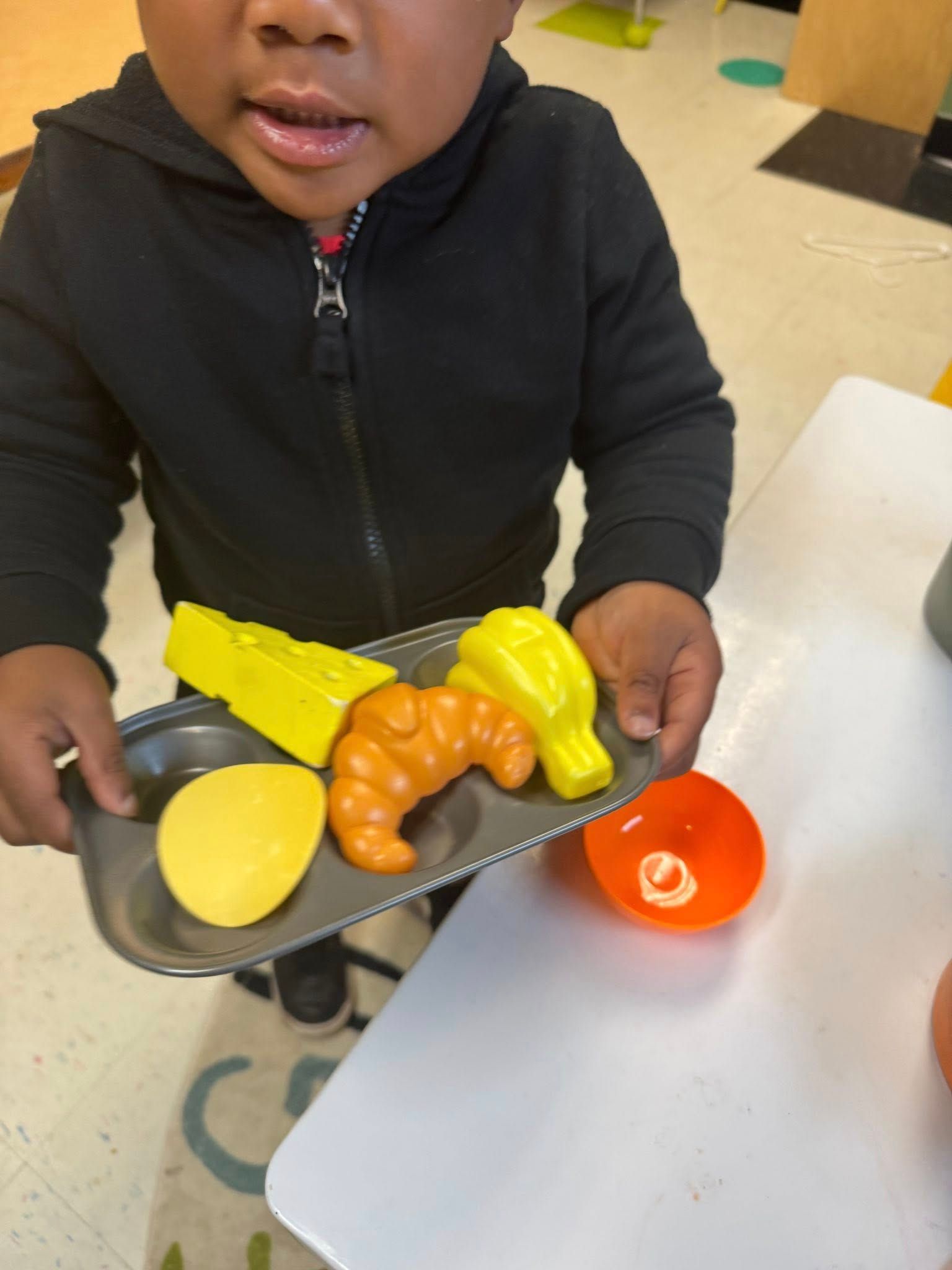 A young boy is holding a tray with food on it