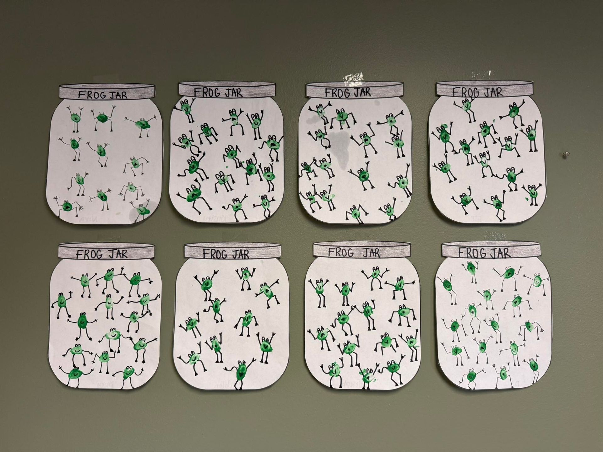 A bunch of jars with green frogs on them