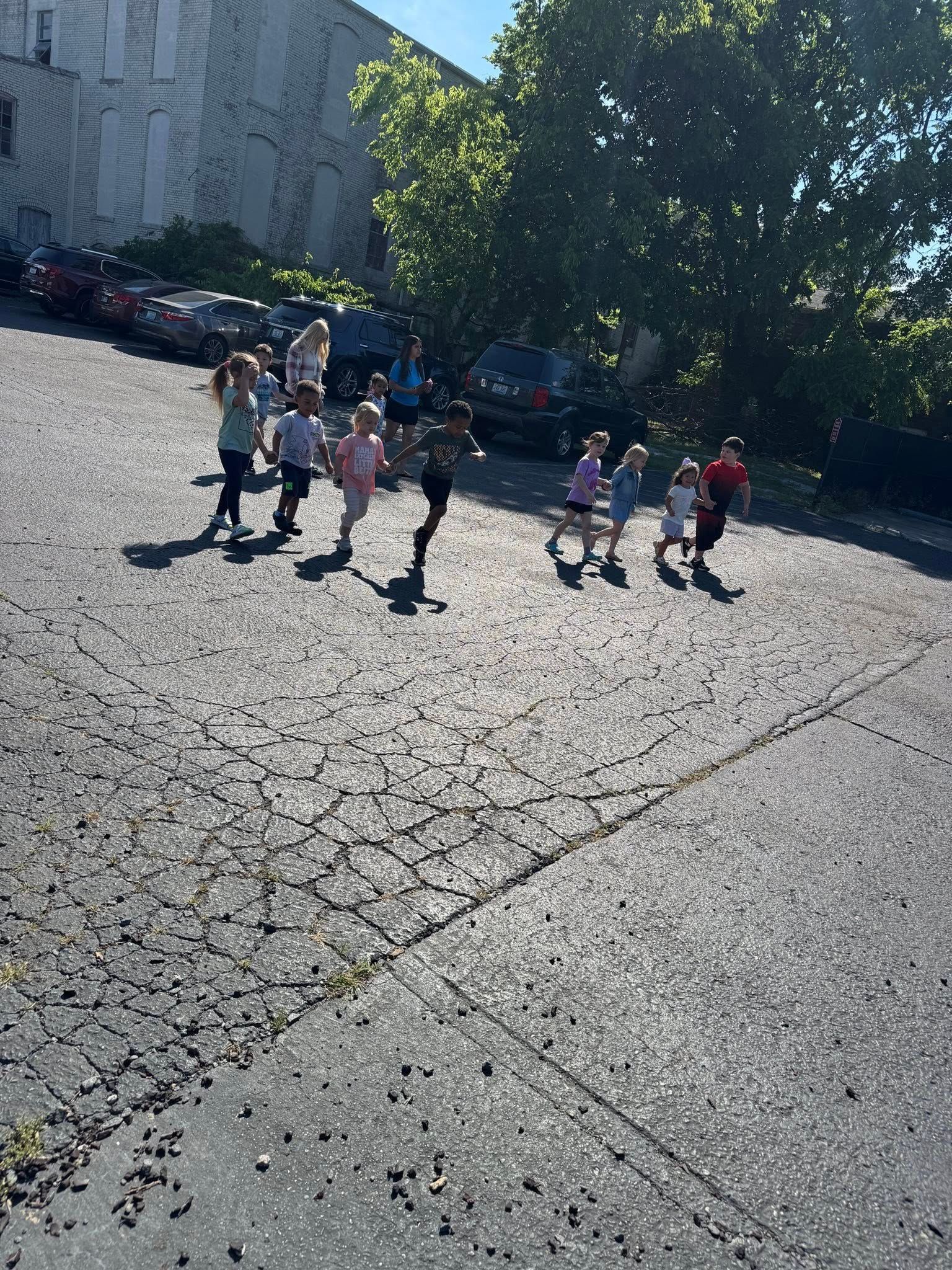 A group of children are running down a street.