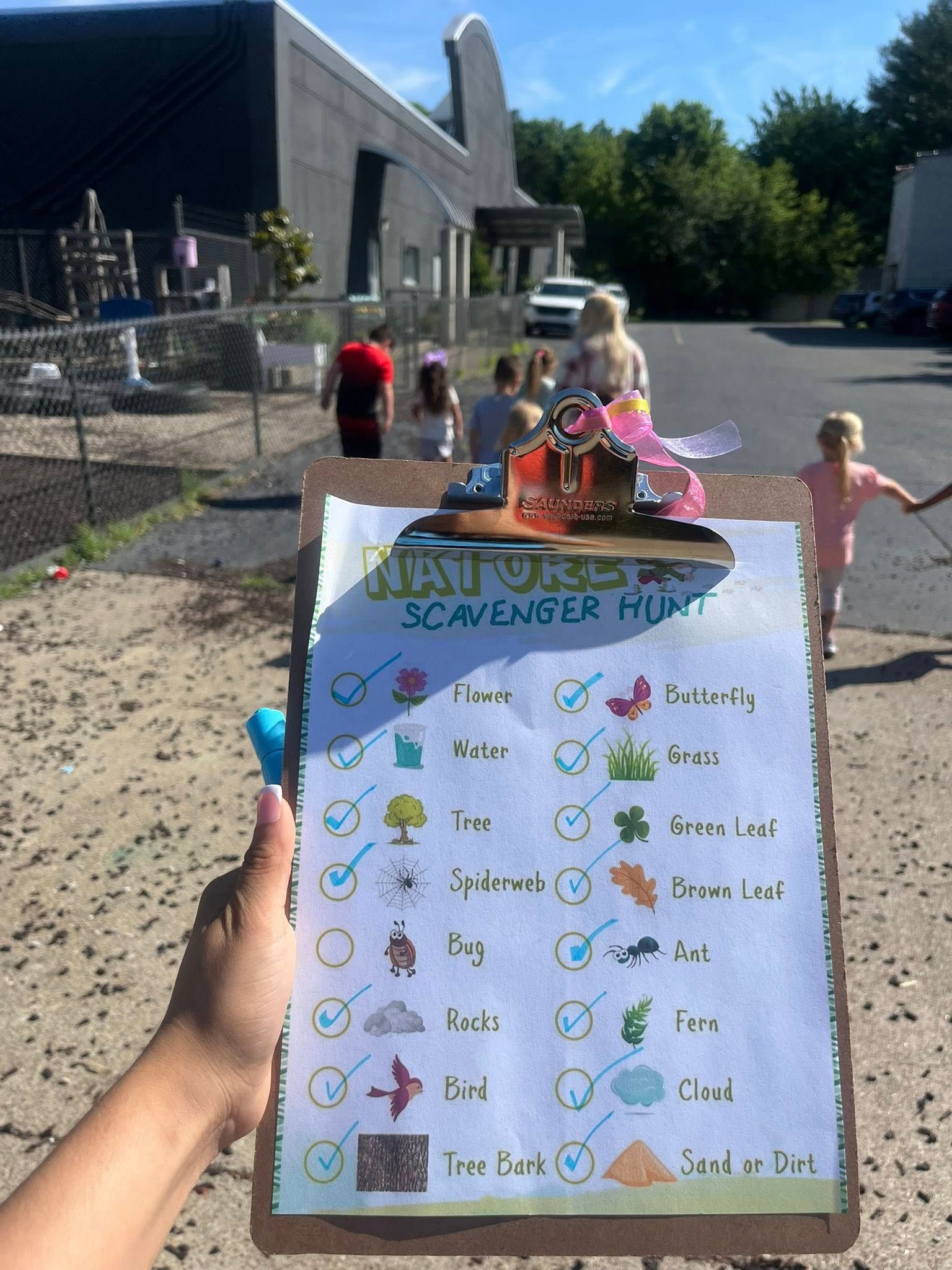 A person is holding a clipboard with a scavenger hunt on it.