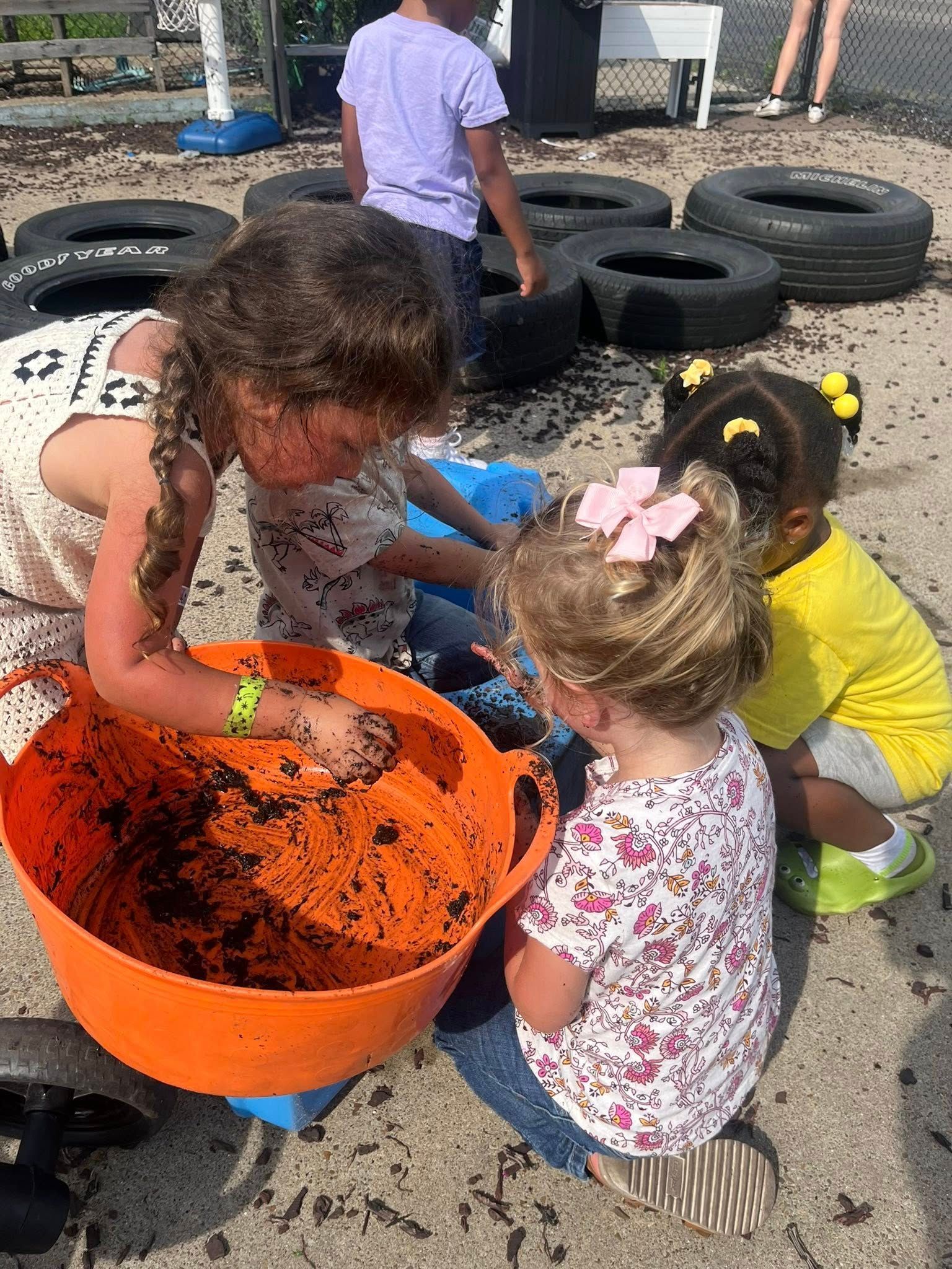 A group of young girls are playing in the dirt.
