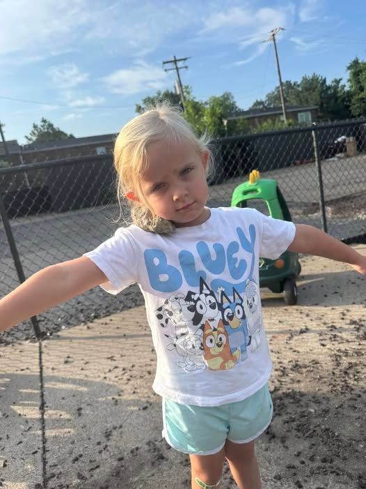 A little girl wearing a shirt that says bluey