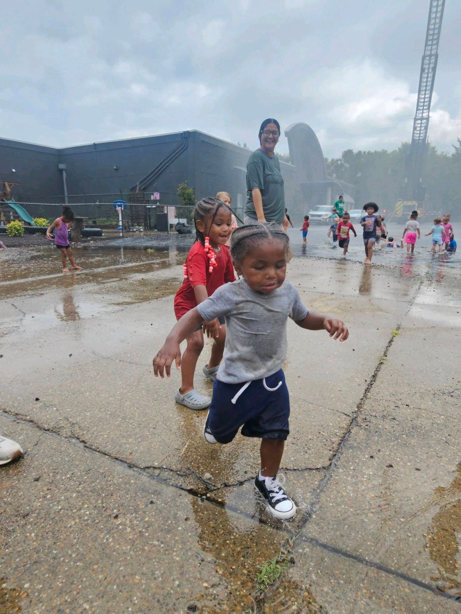 A group of children are playing in a fountain.