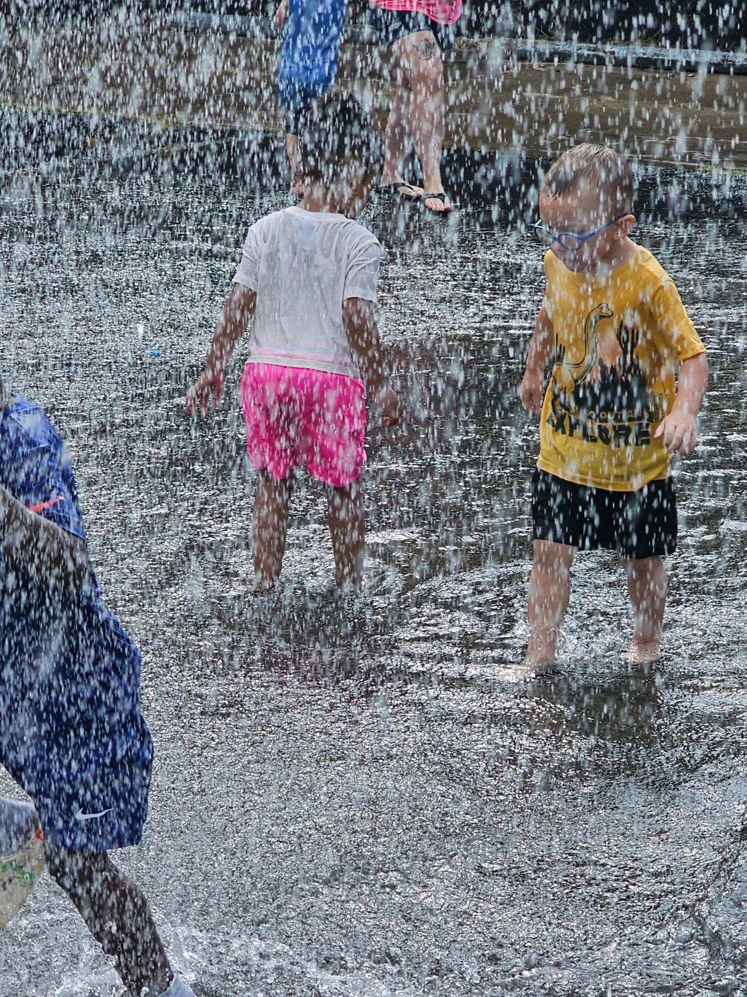 A group of children are playing in the rain.