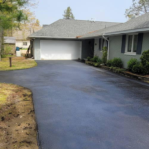 photo of an l-shaped driveway with a fresh sealcoat application