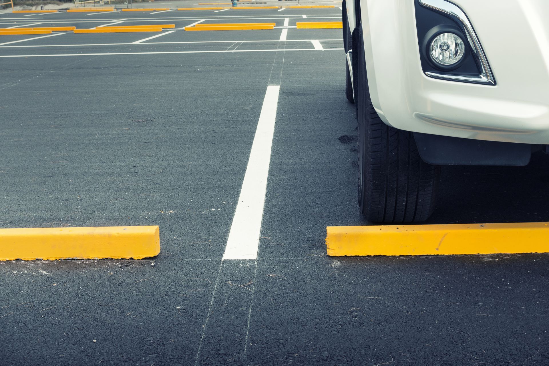photo of a freshly painted line stripe and a car parked on one side of it