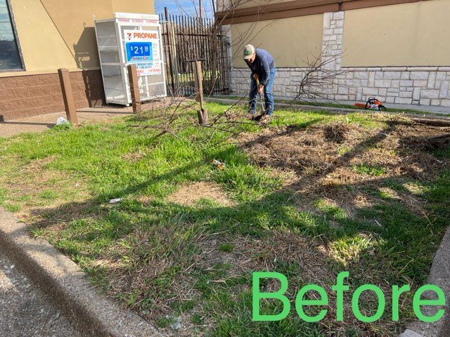 A man is digging in the grass in front of a building.