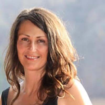 A woman with long hair is smiling for the camera.