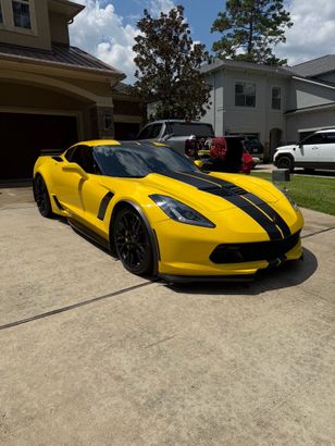 Orange Audi coupe parked under bridge, sunset lighting.