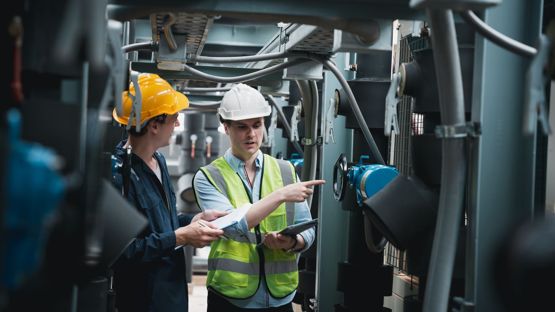 Engineer and team examining the air conditioning cooling system of a huge building or industrial site.