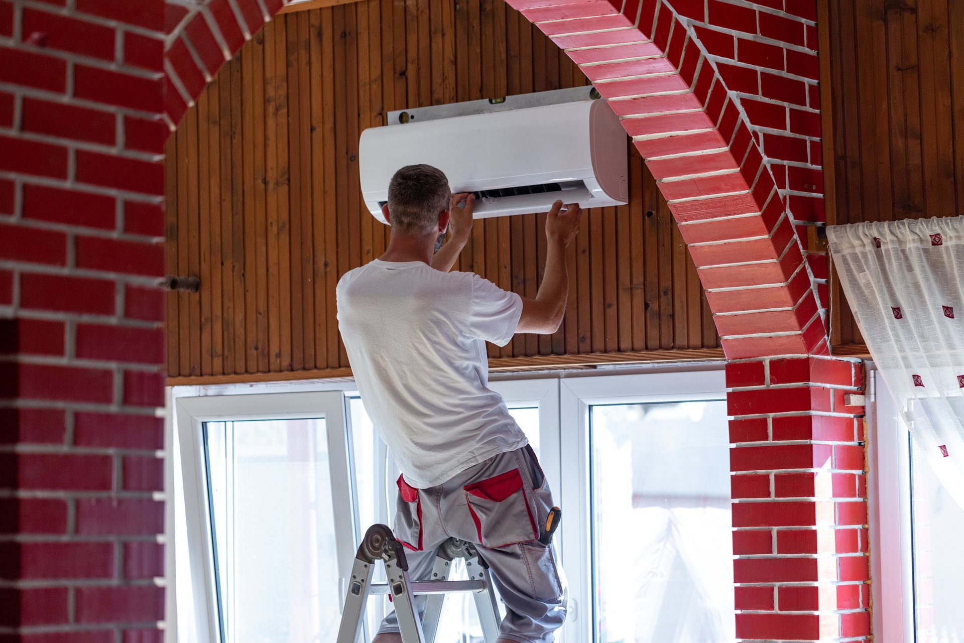 A male worker completing ac replacement in the living room.