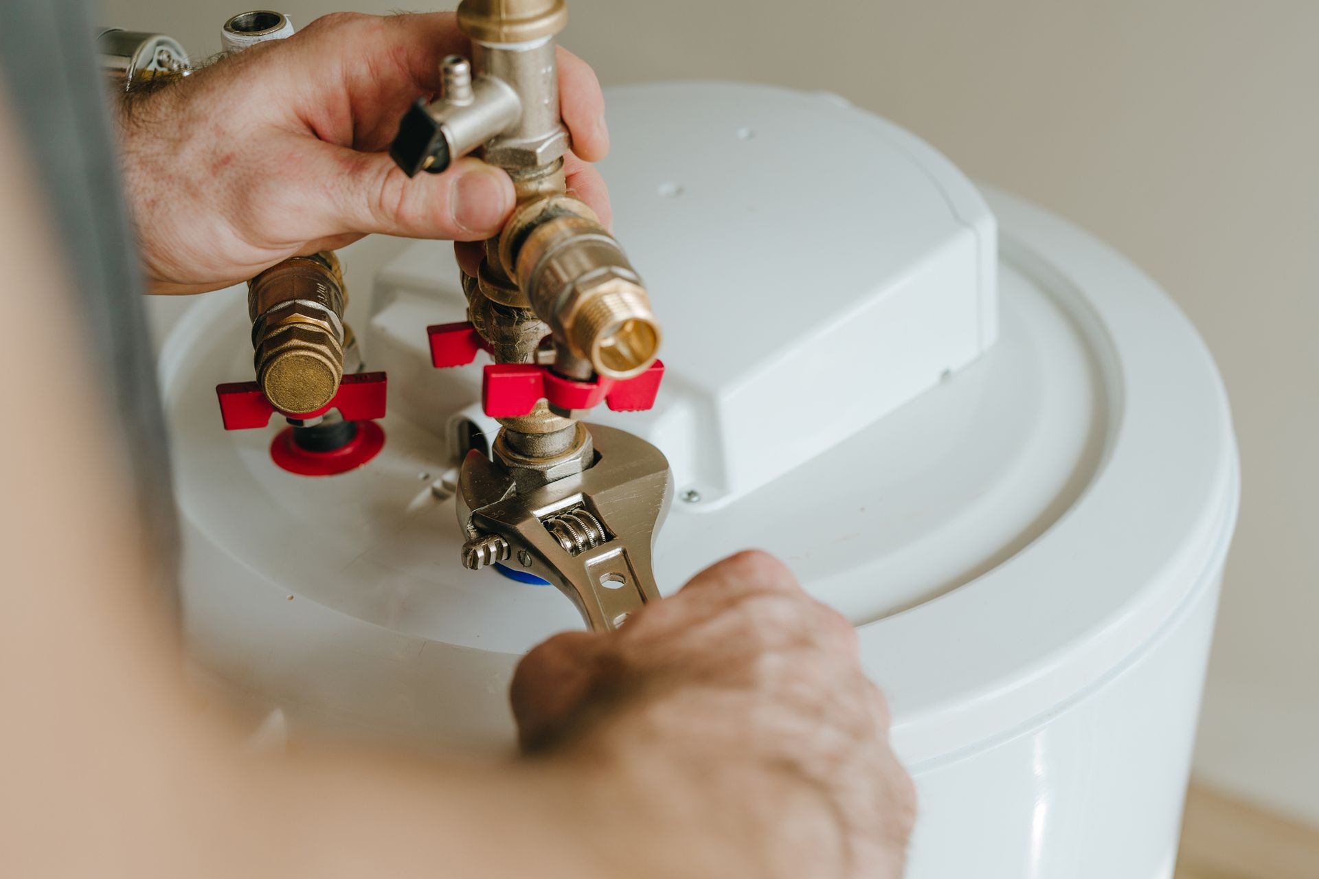 A plumber installing a brand new water heater. A plumber installing a brand new water heater.