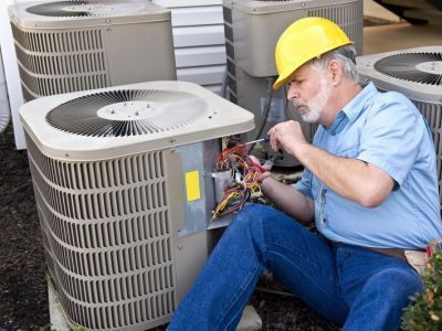 Man Repairing HVAC Unit — Portage, MI — Dan Wood Company
