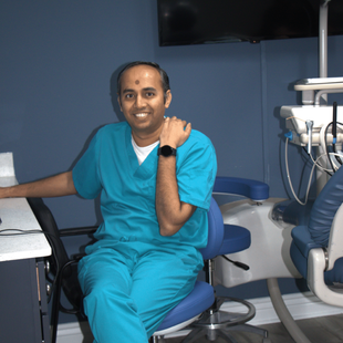 A man in scrubs is sitting in a dental chair