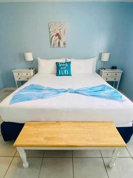 A bedroom with a king size bed and a bench.