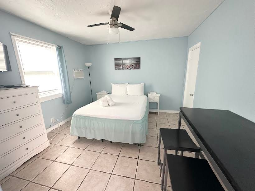 A bedroom with a bed and a ceiling fan
