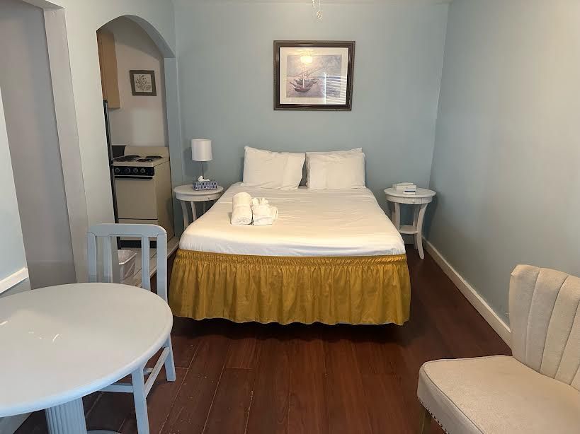 A hotel room with a bed , table and chairs.