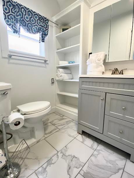 A bathroom with a toilet , sink and mirror