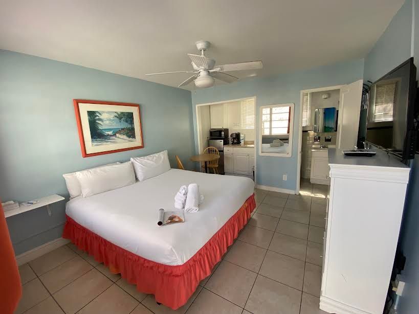 A hotel room with a king size bed and a flat screen tv.
