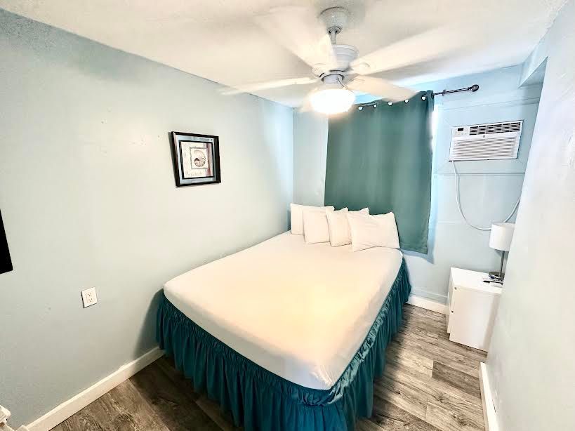 A bedroom with a bed and a ceiling fan.