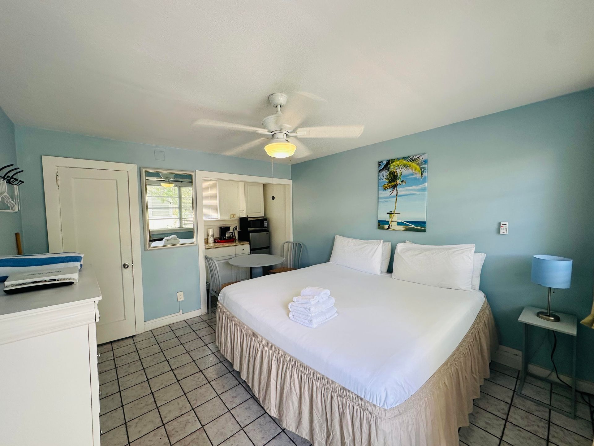 A bedroom with a king size bed and a ceiling fan.
