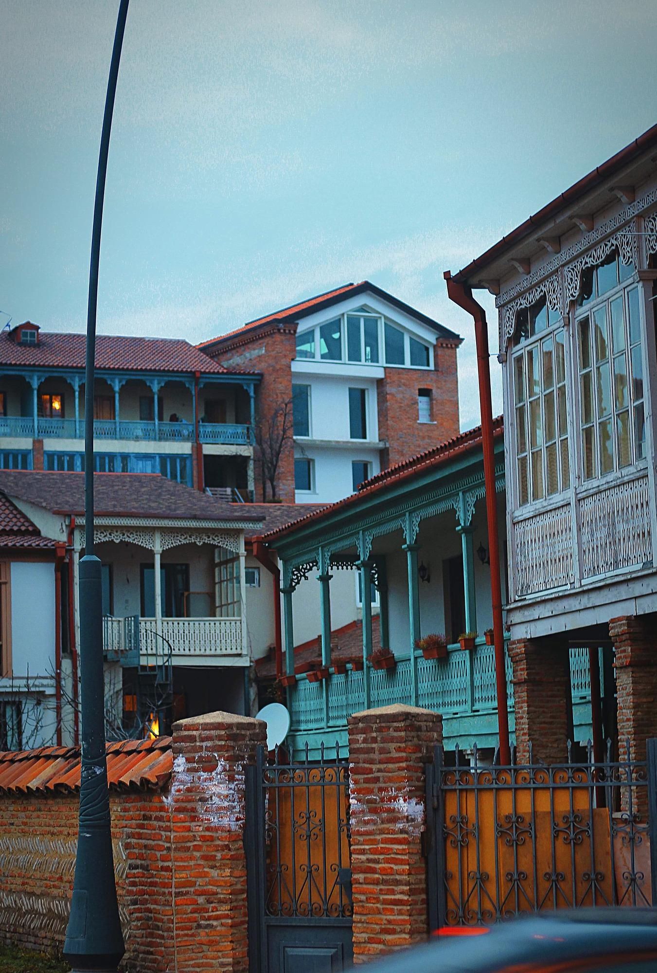 A car is parked in front of a row of houses.