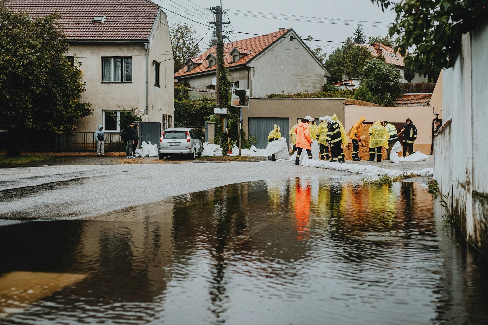 A group of people are standing in a flooded street.
