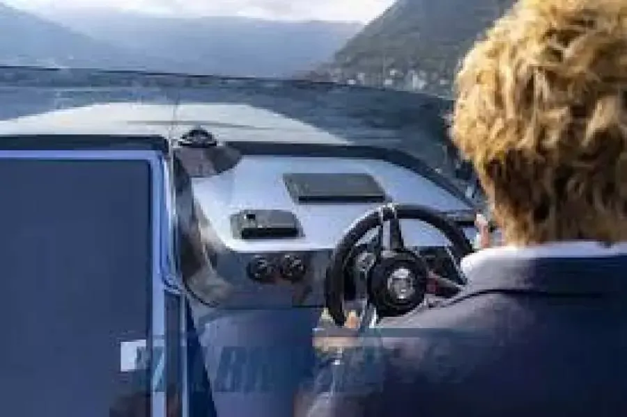 A man is driving a boat on a lake.