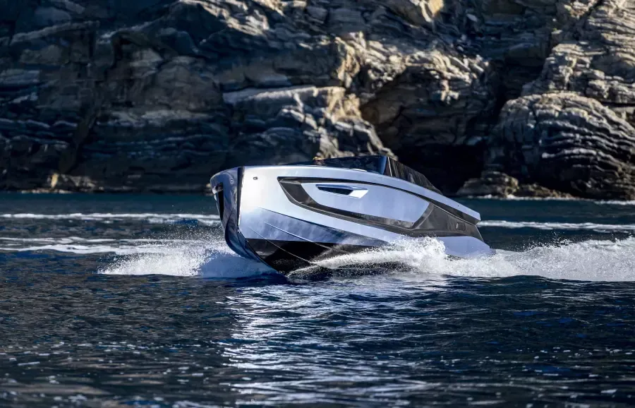 A white and black boat is floating on top of a body of water.