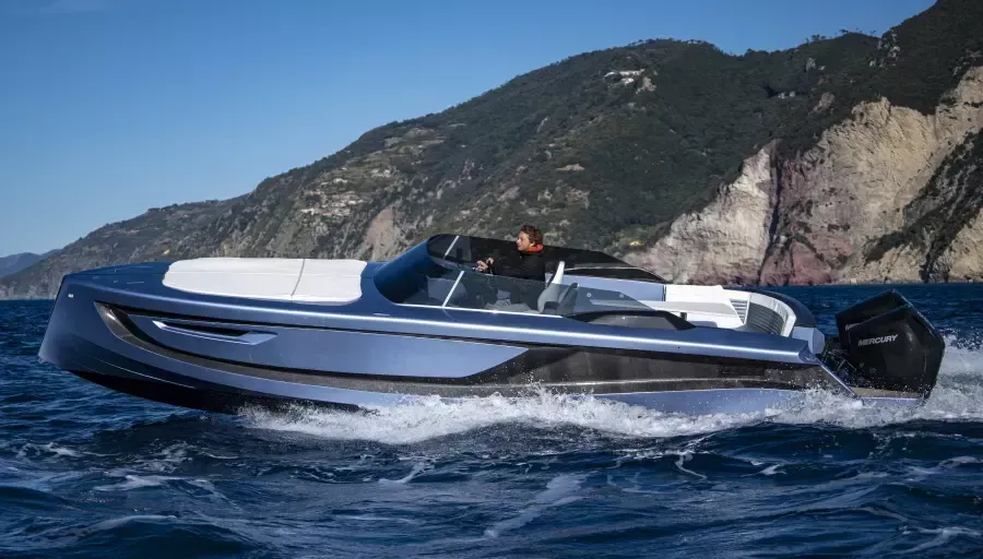 A boat is floating on top of a body of water with mountains in the background.