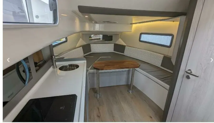 The inside of a boat with a table and a sink.