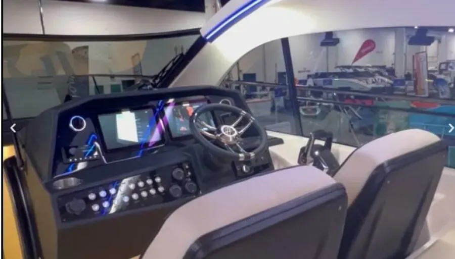 The interior of a boat with a steering wheel and seats.