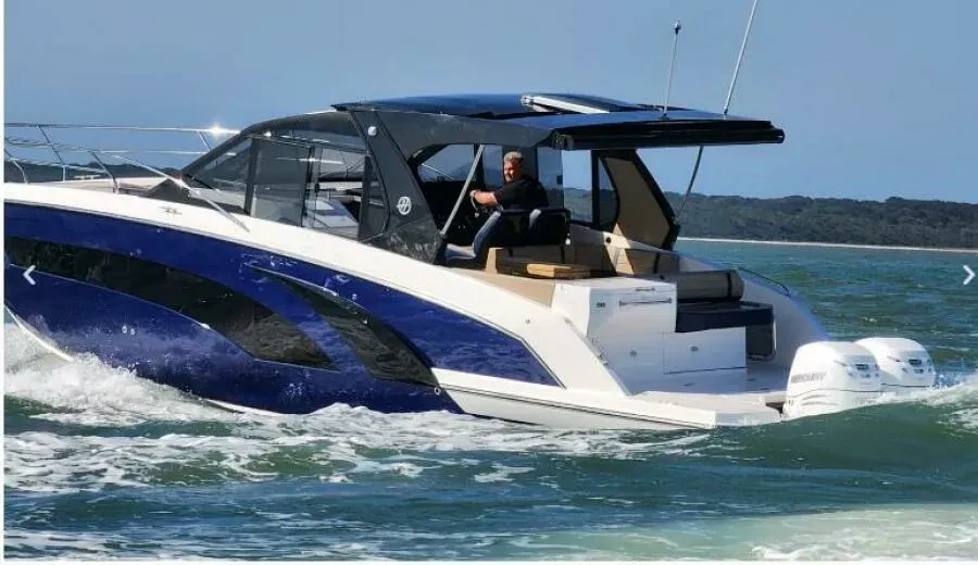 A blue and white boat is floating on top of a body of water.