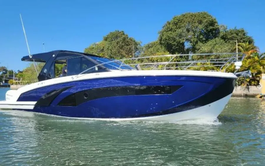 A blue and white boat is floating on top of a body of water.