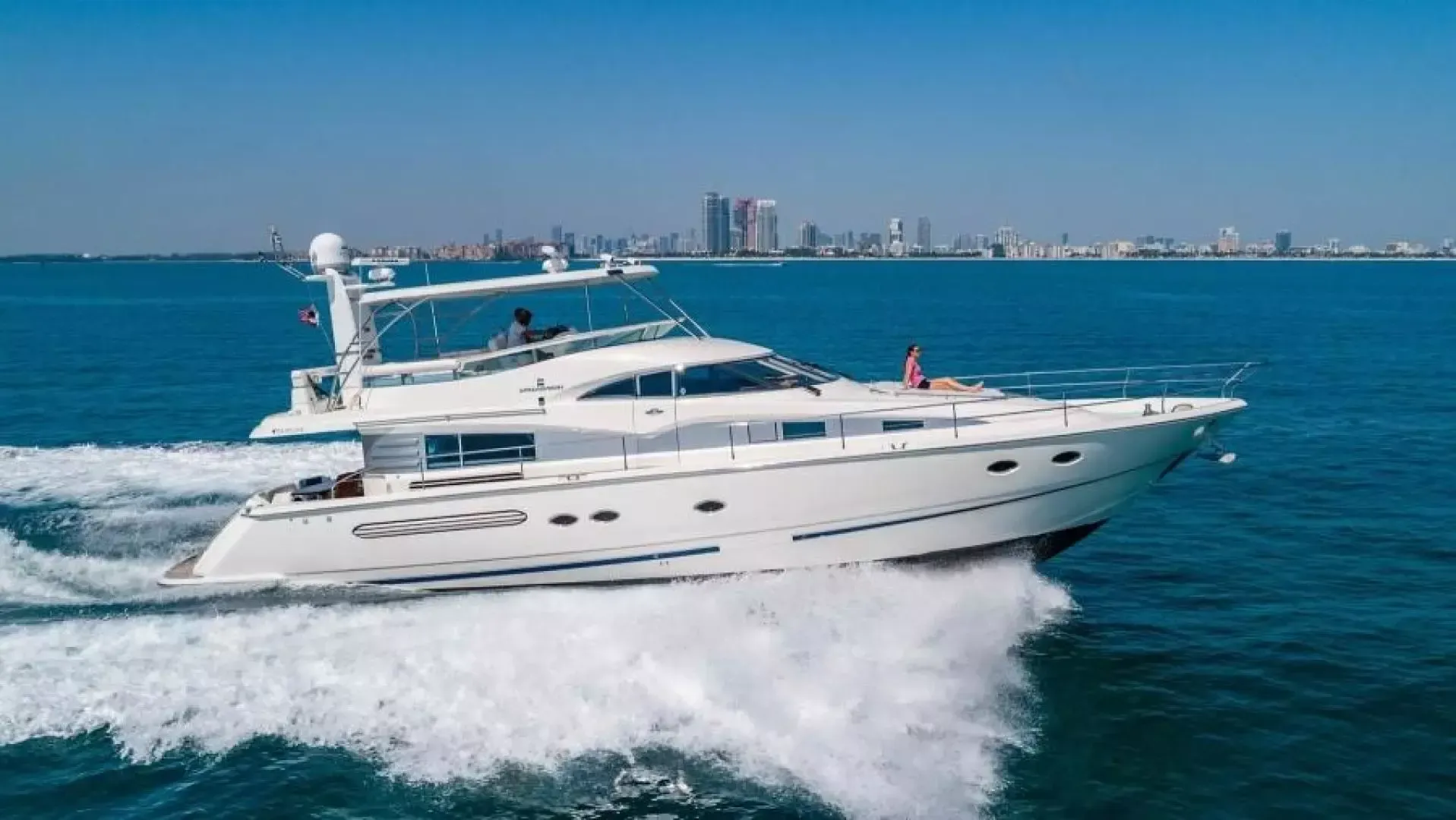 A white yacht is floating on top of a large body of water.