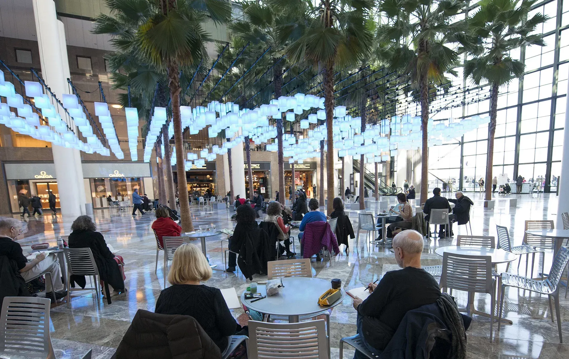 A group of people are sitting at tables in a large room.