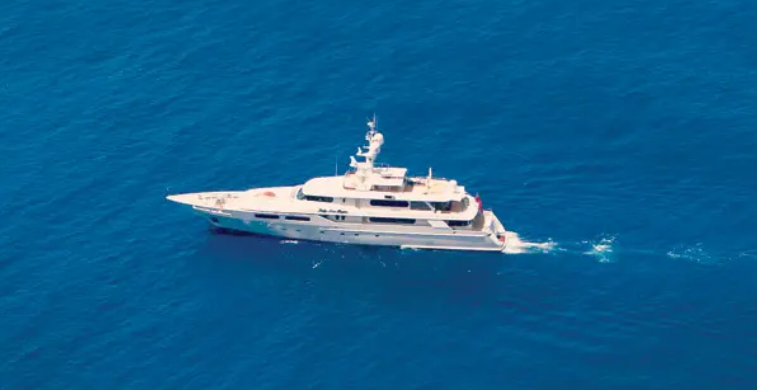 A large blue and white yacht is floating on top of a body of water.